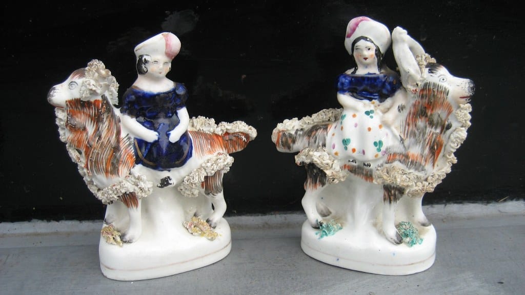 Pair of Staffordshire figurines of girls on he-goats